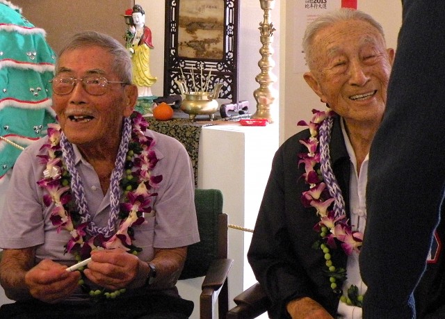 Jiro Yukimura, 92, left; and Turk Tokita, 92, chat with audience members after their presentation at the Kauai Museum and autograph copies of "Kauai Stories" in which their stories about their World War II are included.