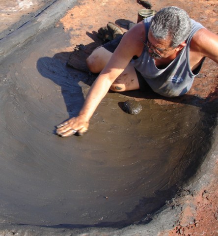 Frank Santos applying the clay to make a punee (bed) where the salt from ocean water will crystallize. Photo courtesy Kuulei Santos